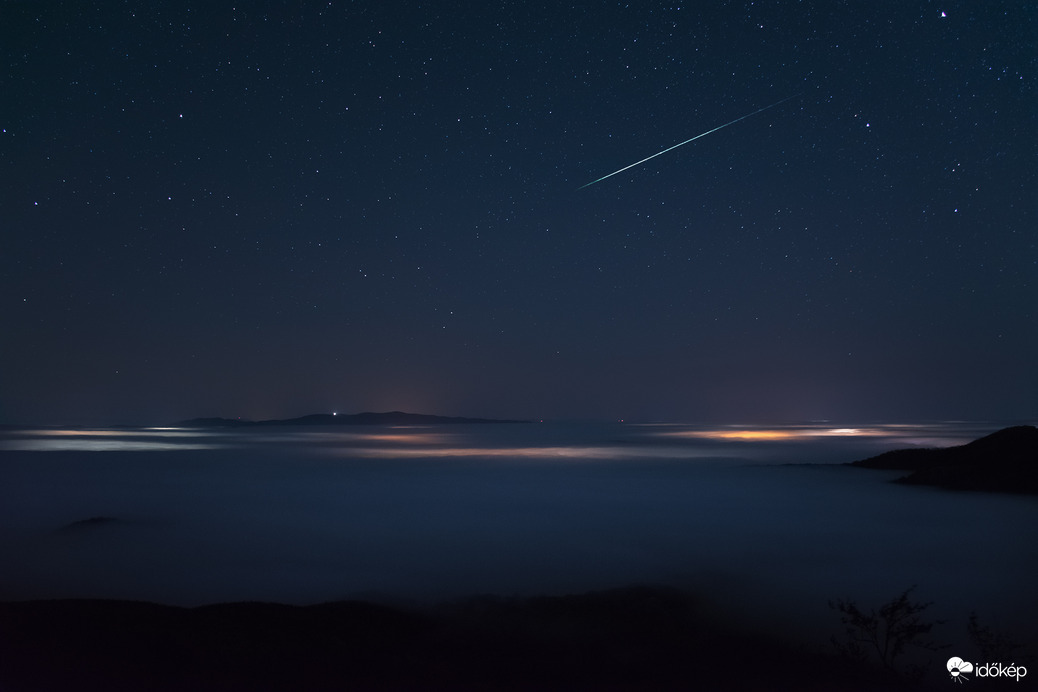 Esti ködös hangulatkép egy fényes meteorral Dobogókőn.